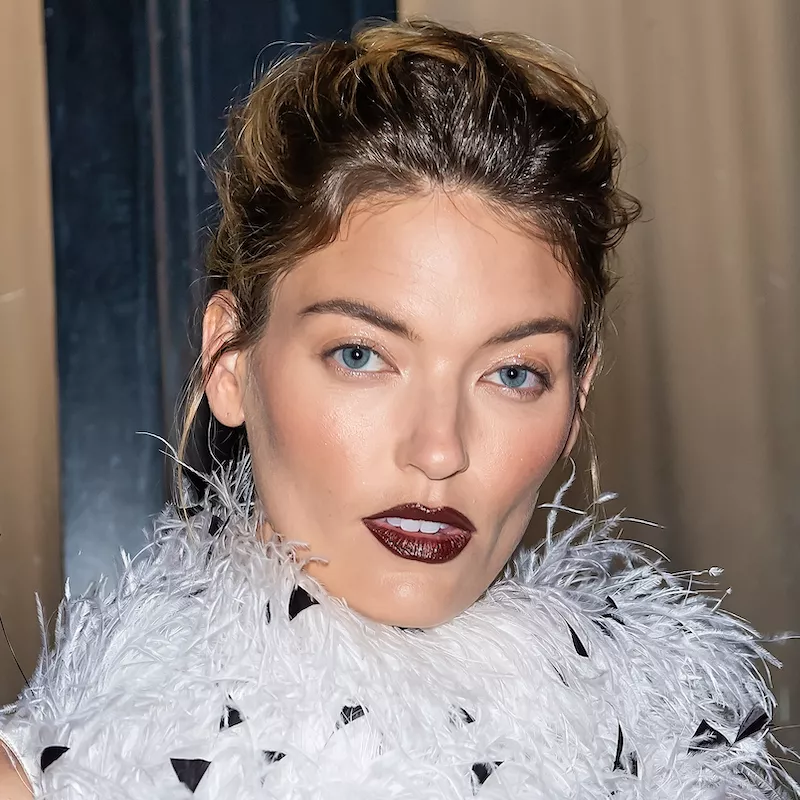 Martha Hunt wears a radiant makeup look with burgundy lipstick