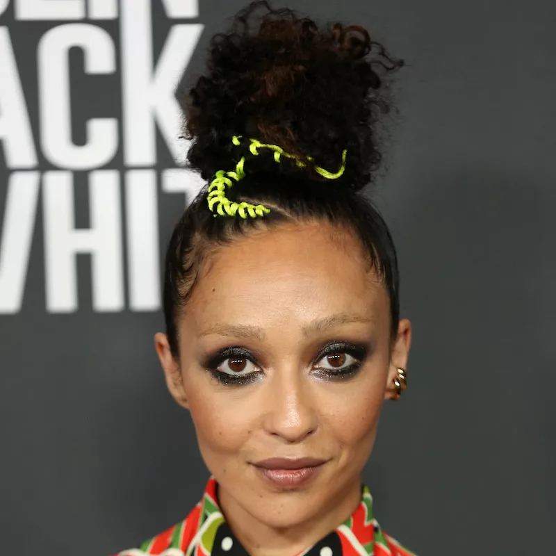 Ruth Negga wears a smudged smoky eye look and curly top knot