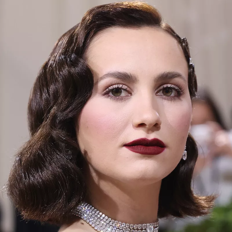 Maude Apatow wears minimal liquid liner with dark red lipstick and old Hollywood waves