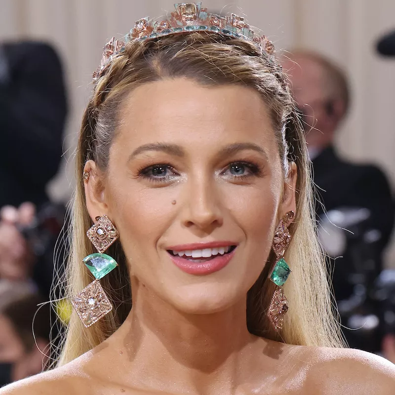 Blake Lively wears sparkling eyeshadow, pink lipstick, and a crown
