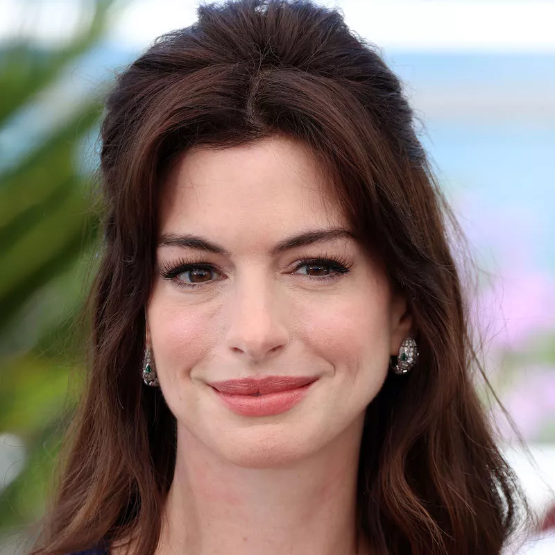 Anne Hathaway wears a warm-toned makeup look with subtle liner and lashes