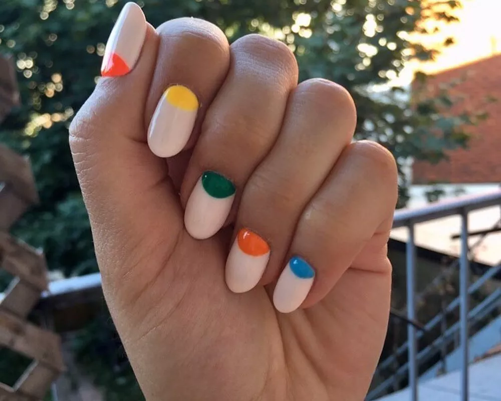 Neutral manicure with multicolored half-moon nail design at base