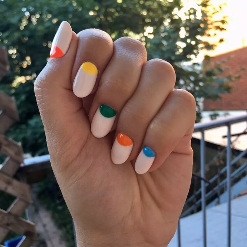 Neutral manicure with multicolored half-moon nail design