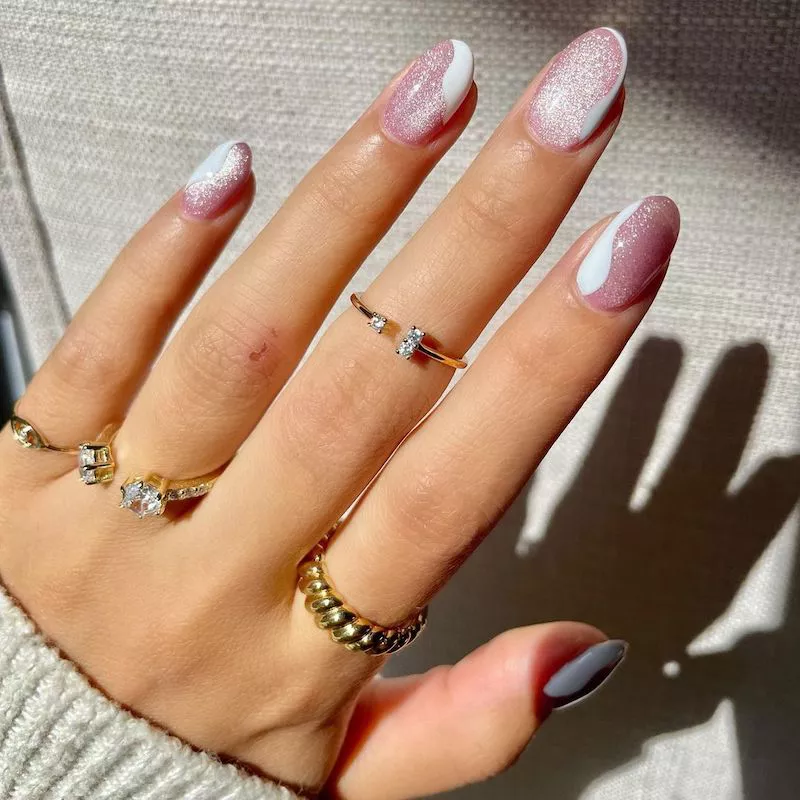 Pink and white glitter wavy manicure with gold rings