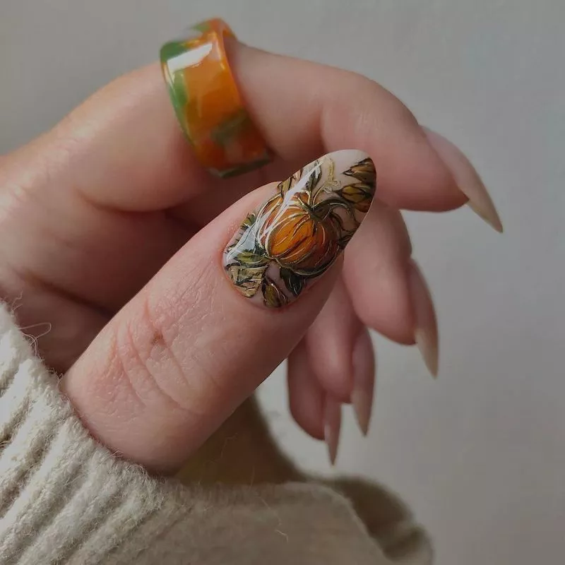 Painterly pumpkin nail design and orange and green ring