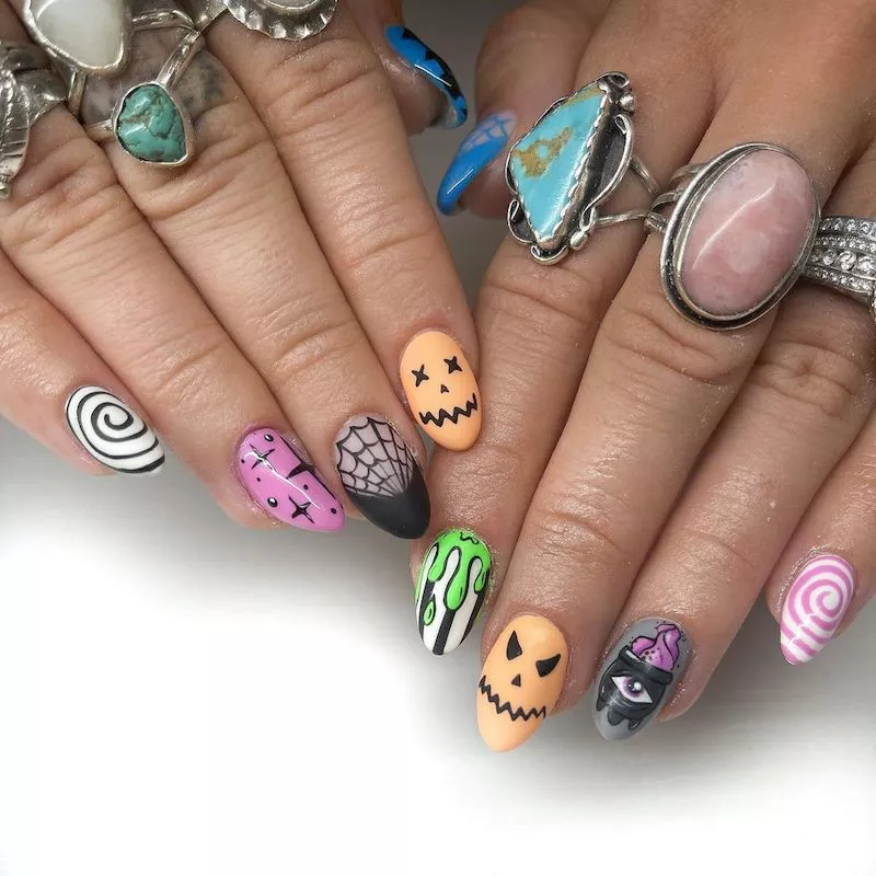 Multi-patterned manicure with cauldron, vortex, Beetlejuice slime, and pumpkin nail designs