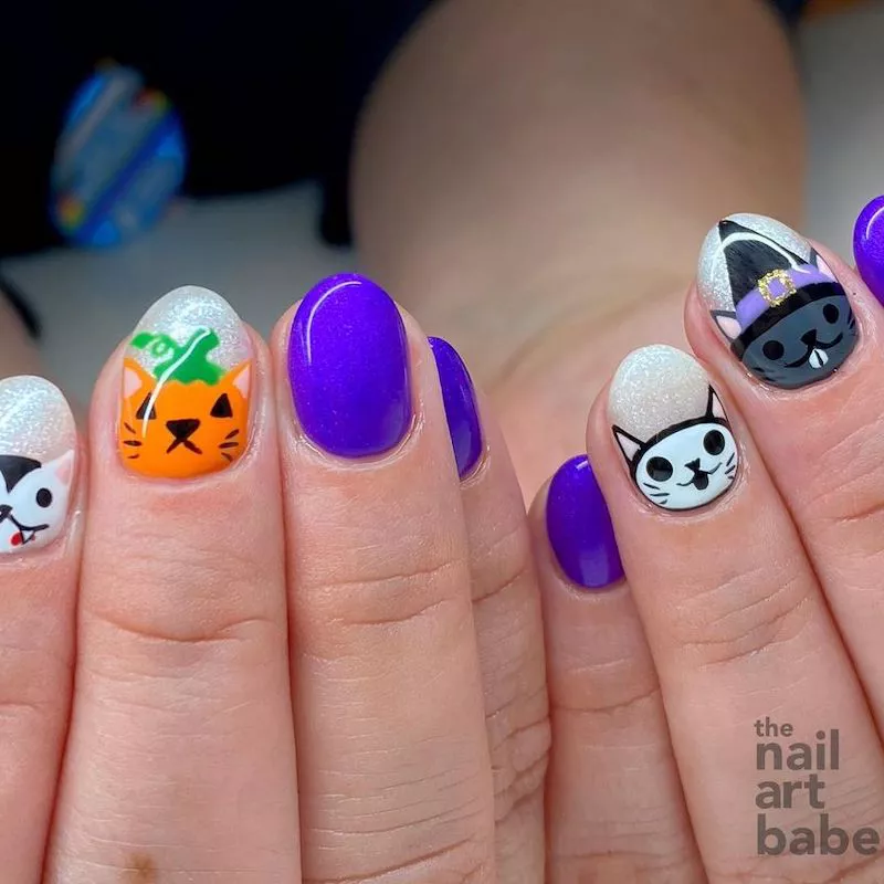 Purple manicure with vampire, skeleton, witch, and pumpkin cat nail designs