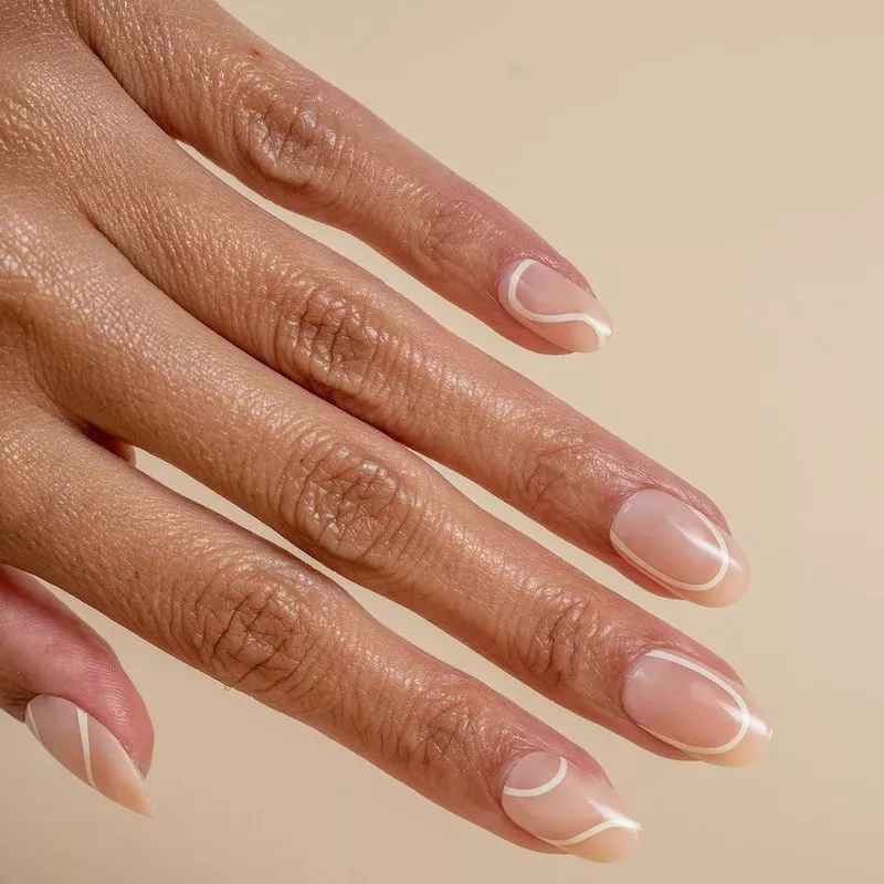 Clear manicure with white curving lines