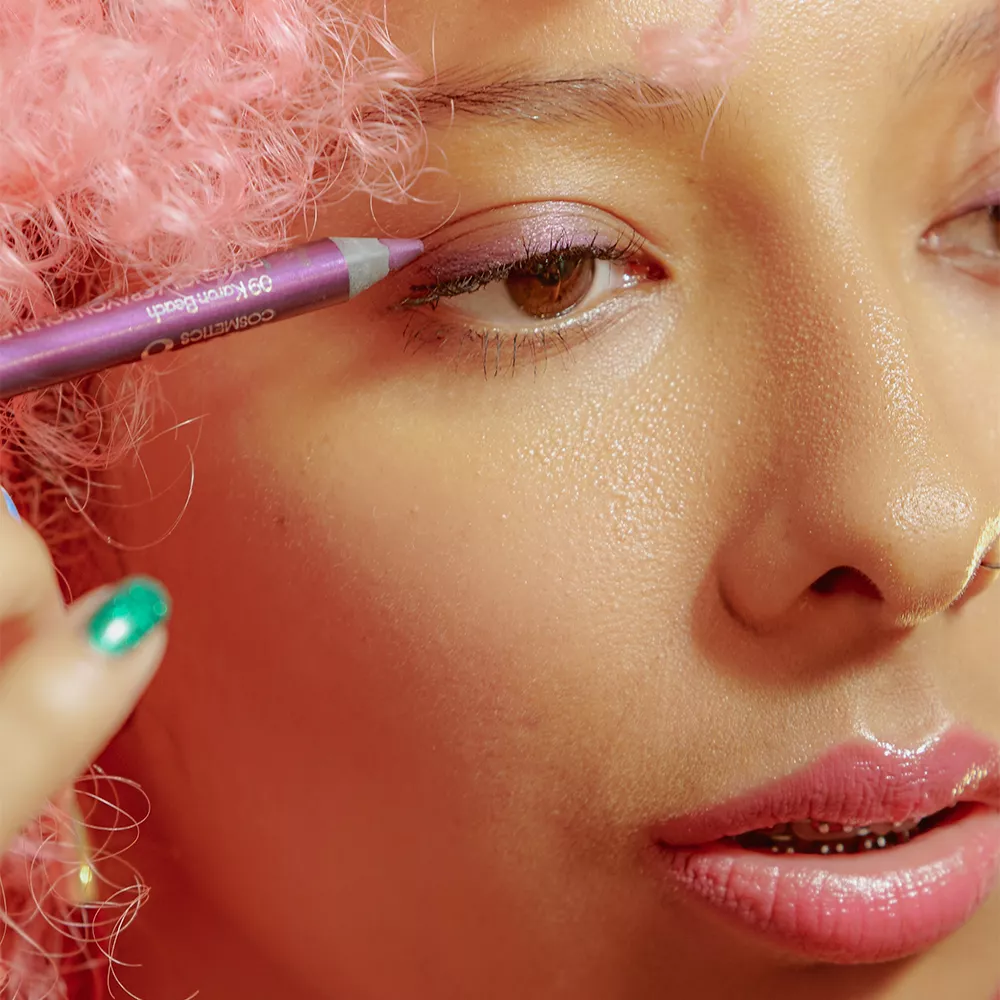 girl putting on eyeliner in pink aesthetic