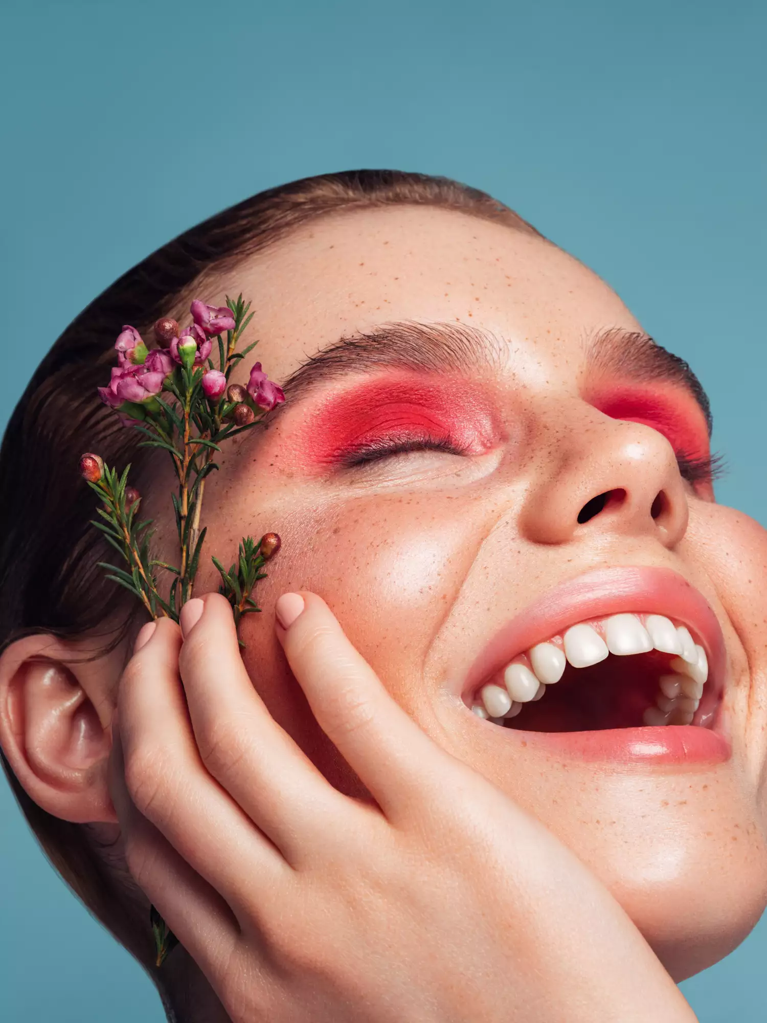 woman laughing with bold eye shadow