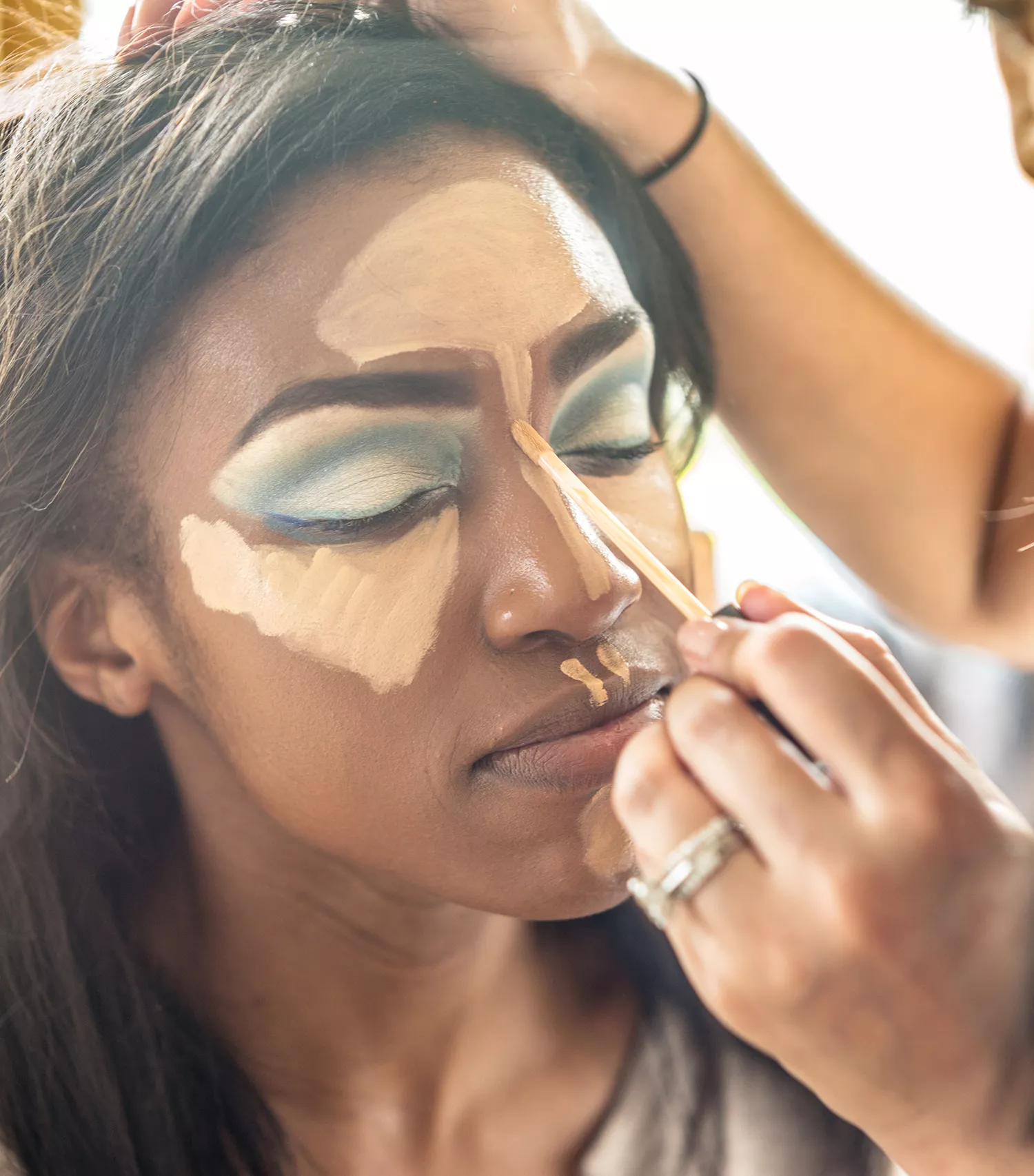Makeup artist contouring with concealer