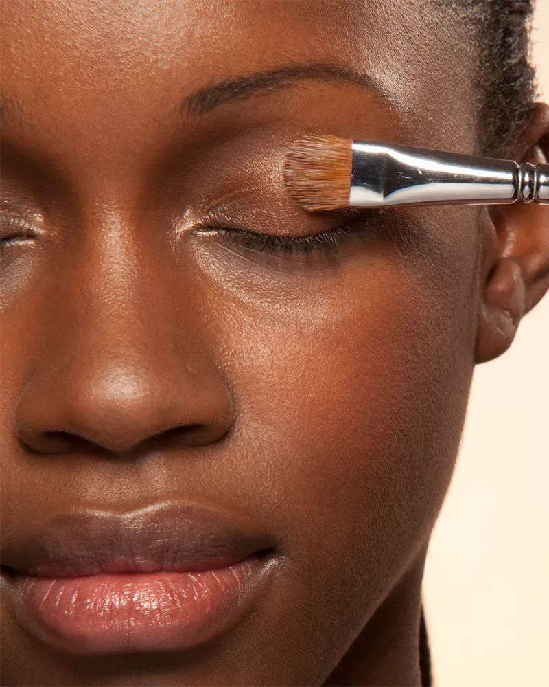 closeup of makeup brush on woman's eyelid