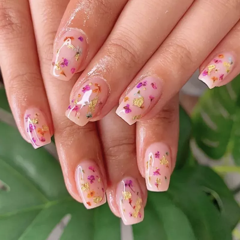 Milk bath nails with pink and purple flowers and gold flakes