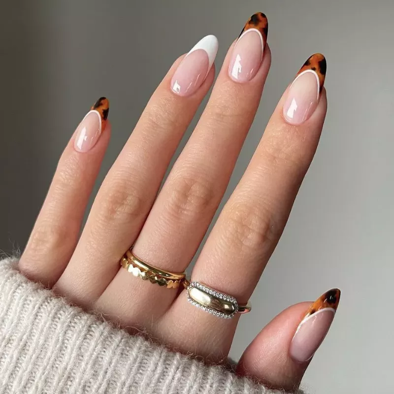 French manicure with tortoiseshell tips and white accent nail