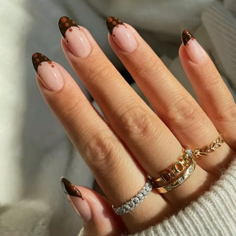 Manicure with dark brown French tips and light brown dots on top