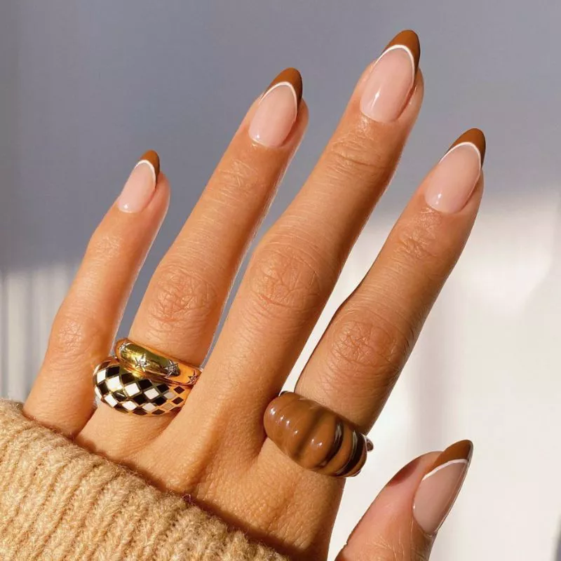 Brown French tip manicure with thin white dividing line