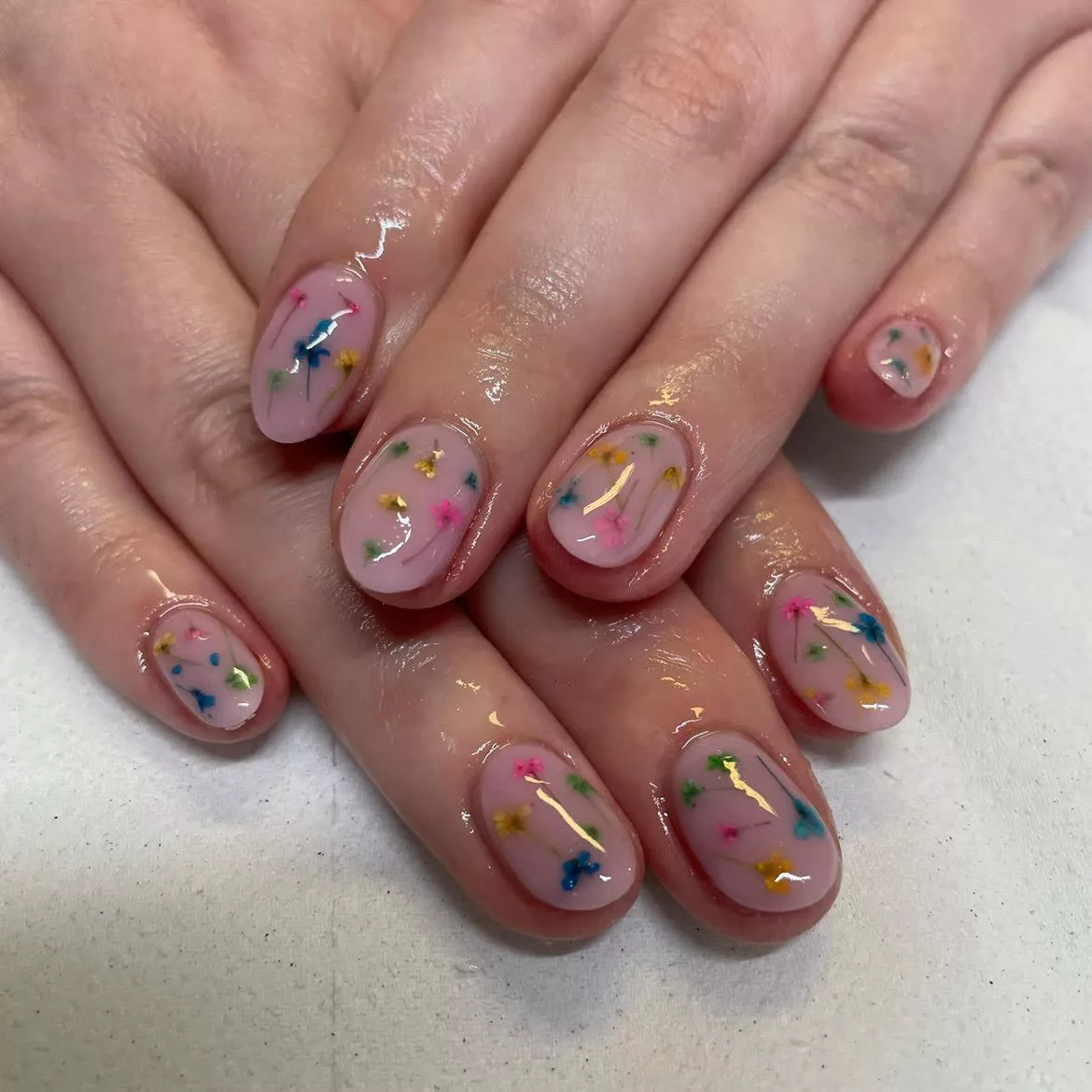 Milk bath nails with pink, blue, and yellow flowers