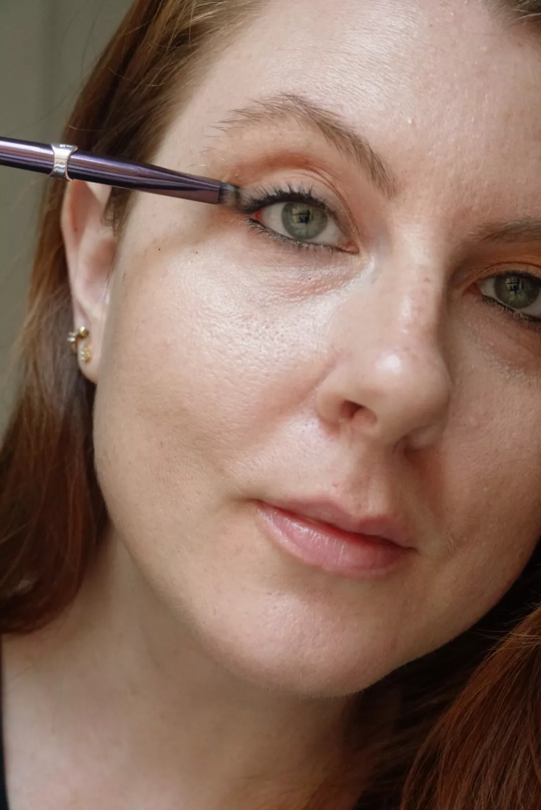 Makeup artist and Byrdie writer Ashley Rebecca blending eyeliner with eye makeup brush