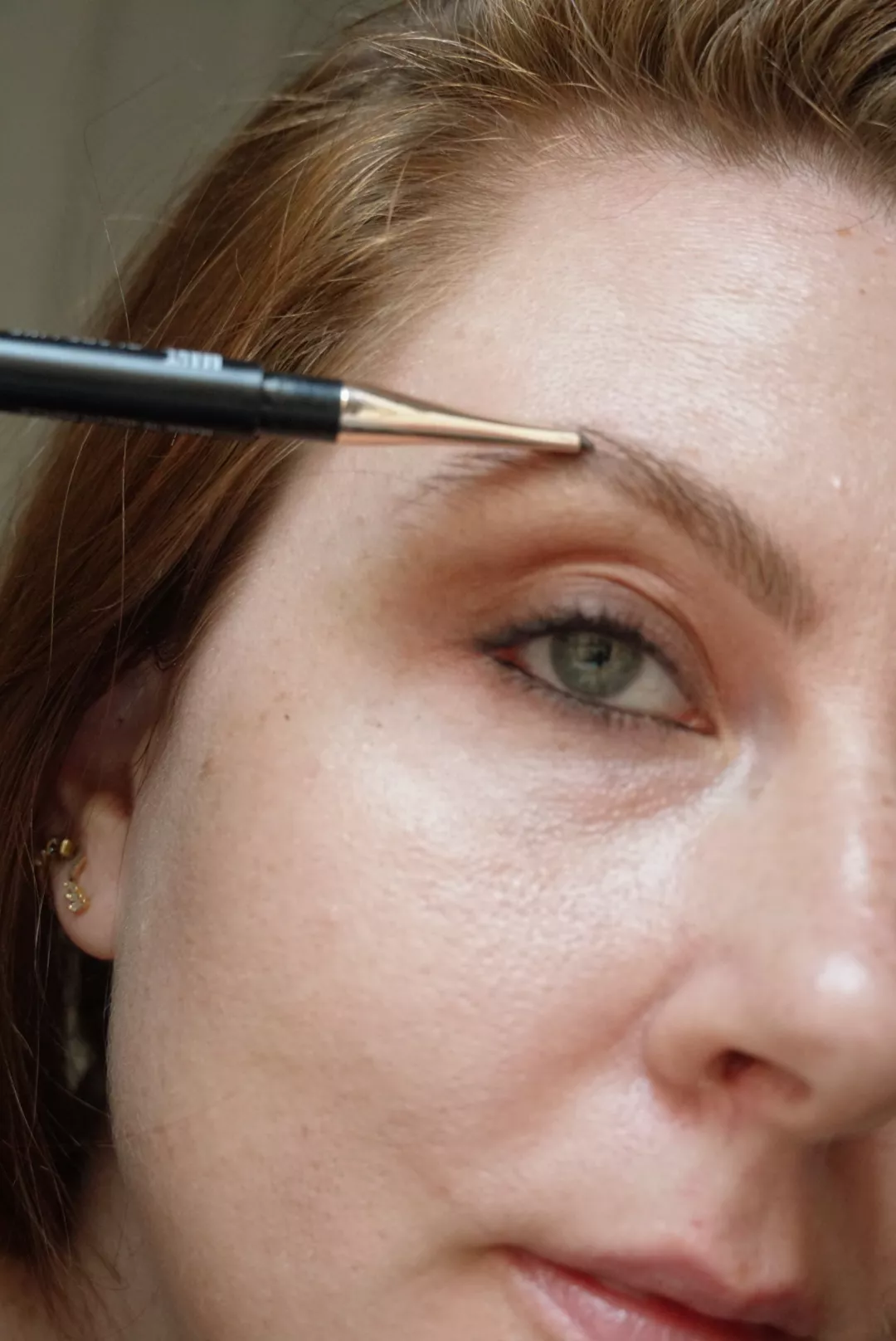 Makeup artist and Byrdie writer Ashley Rebecca fills in eyebrows with brow pencil