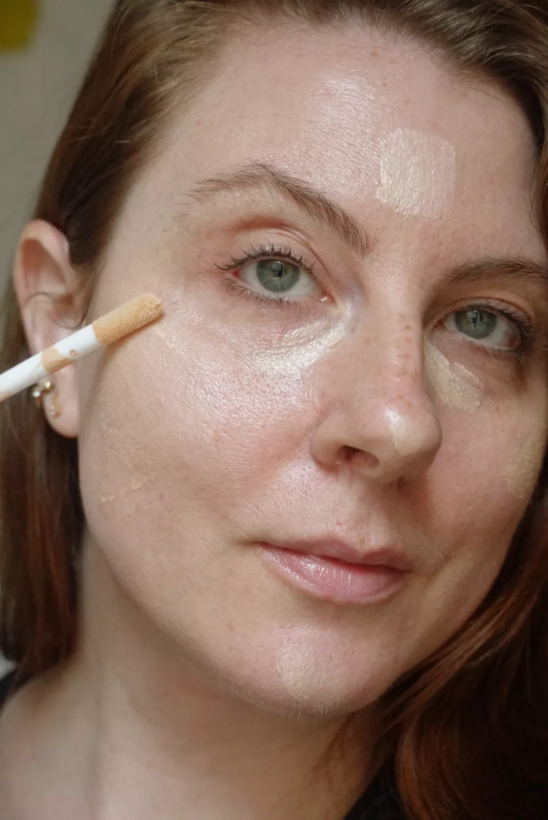 Makeup artist and Byrdie writer Ashley Rebecca applies highlighter to skin