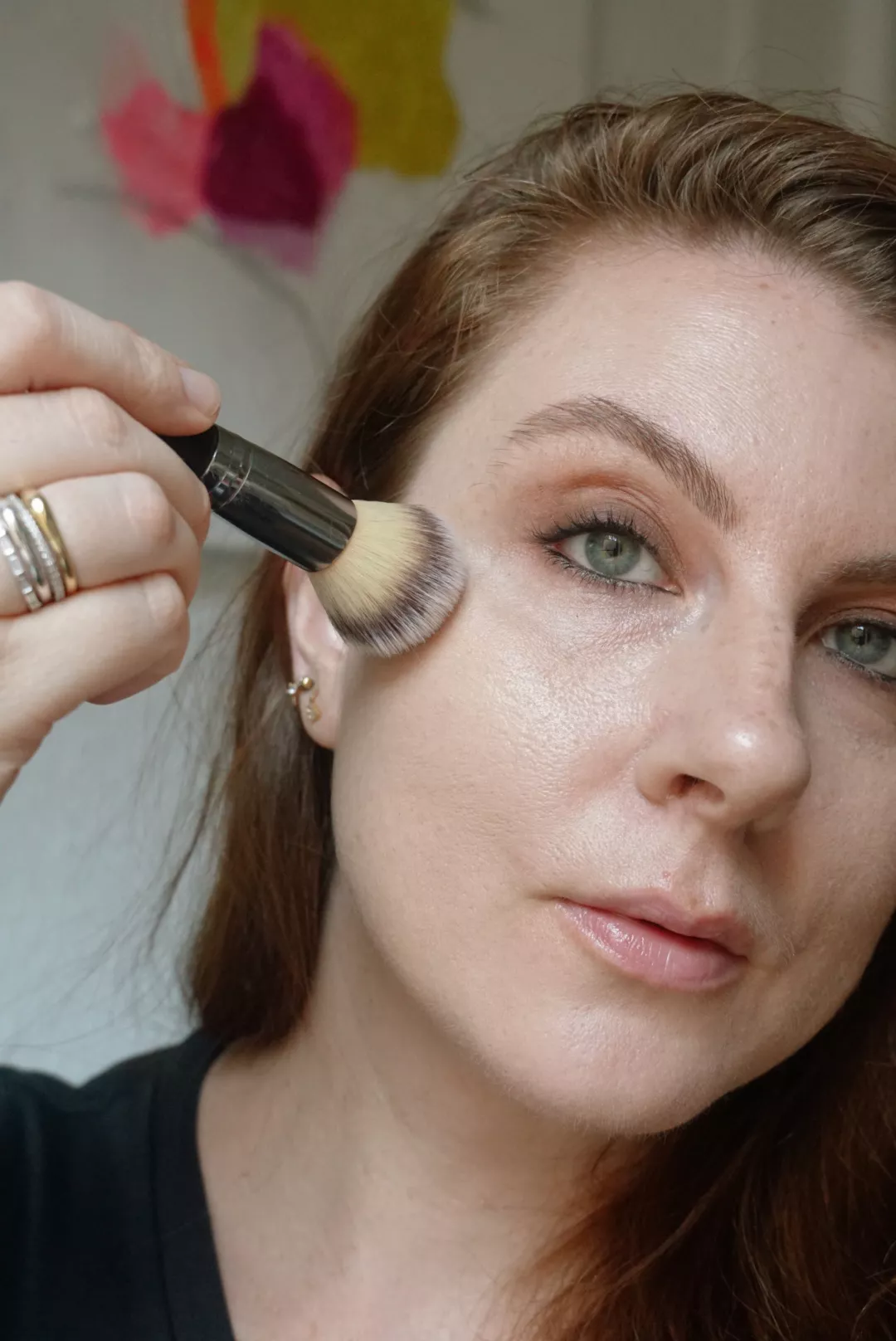 Makeup artist and Byrdie writer Ashley Rebecca applies foundation with a fluffy brush