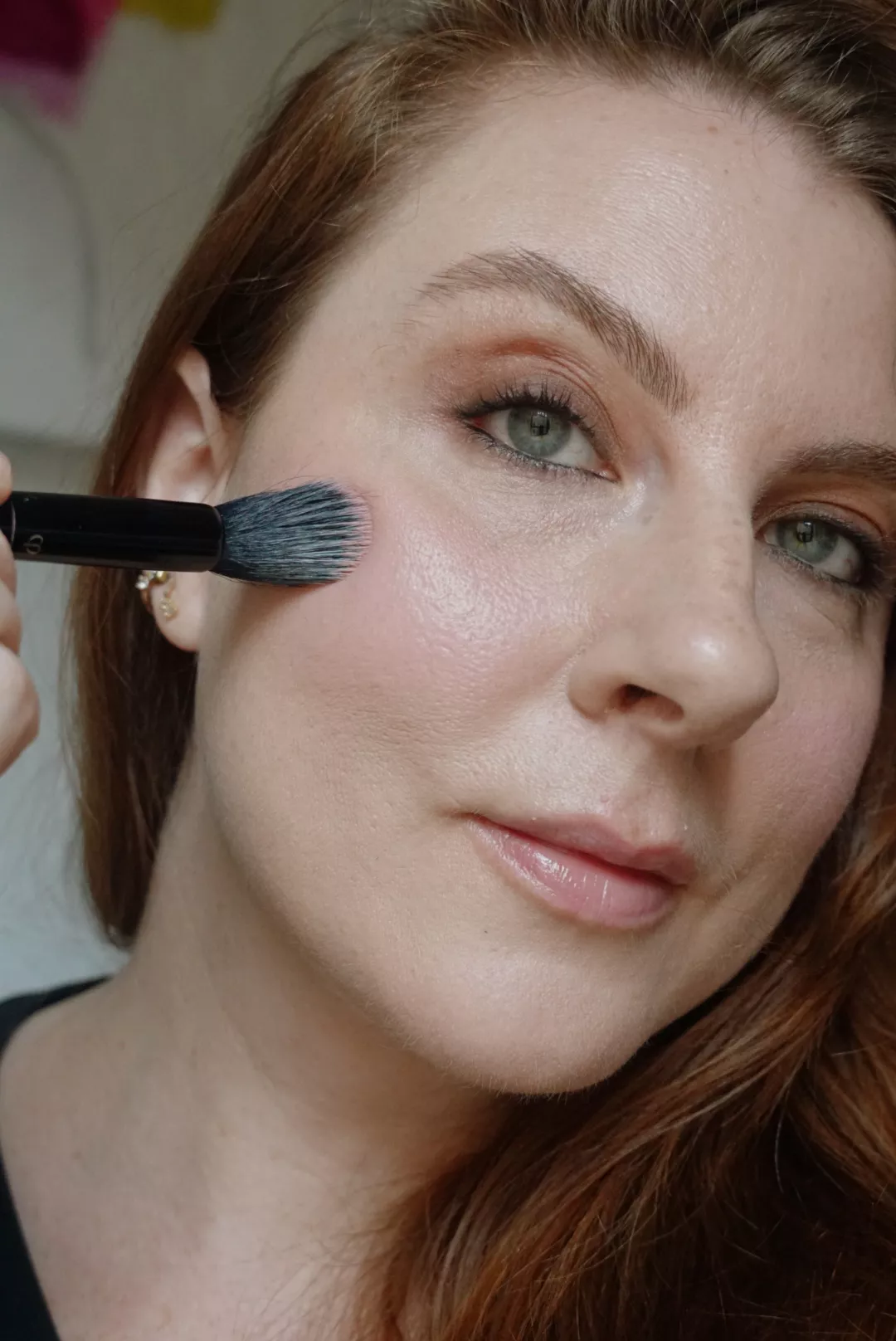 Makeup artist and Byrdie writer Ashley Rebecca applies pink cream blush to cheeks