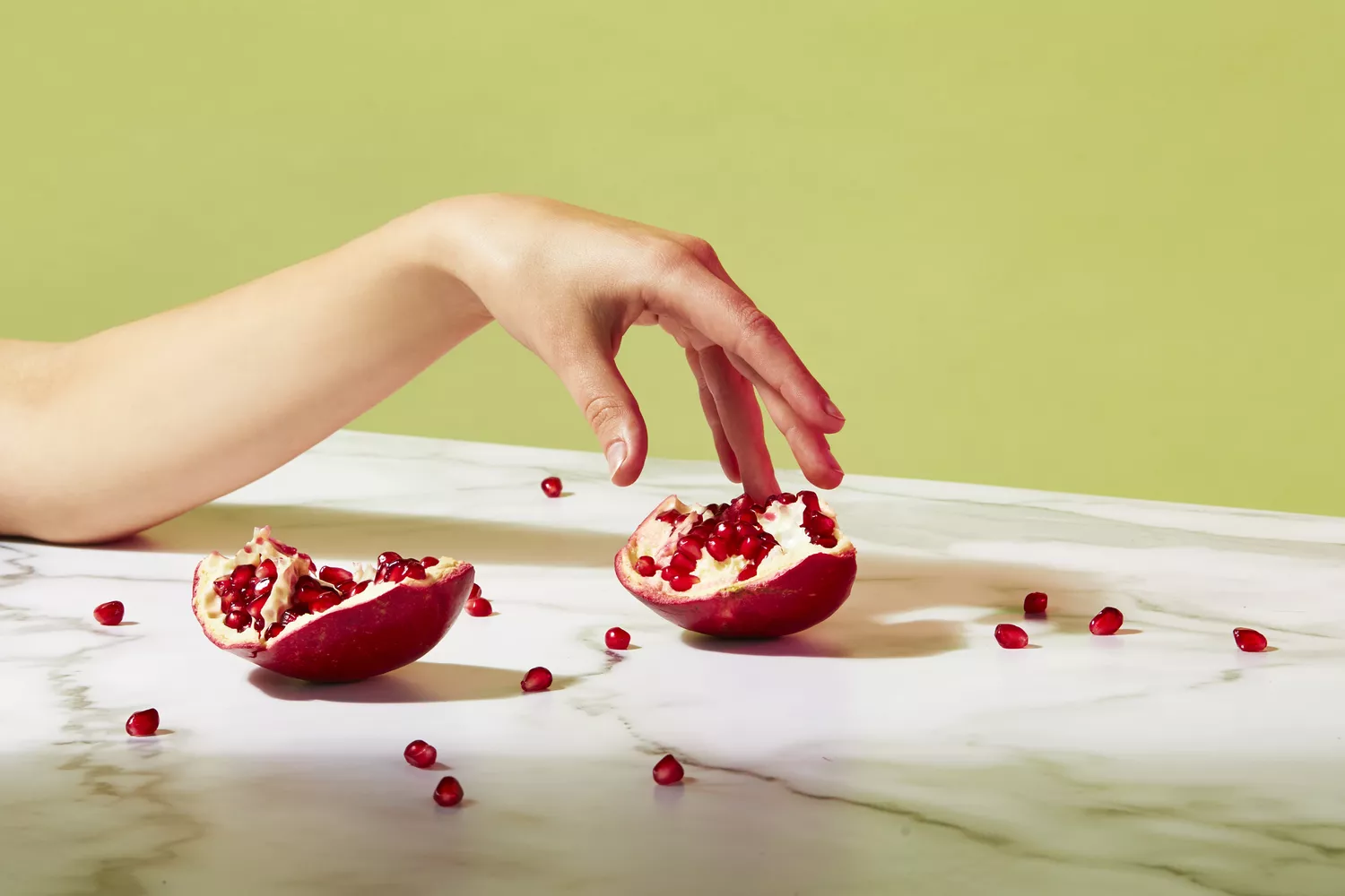 arm and pomegranate in strong lighting