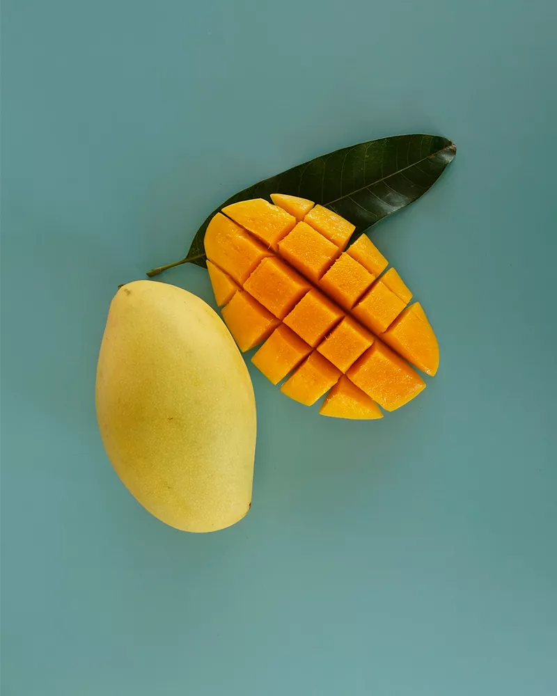 open faced mango on teal backdrop