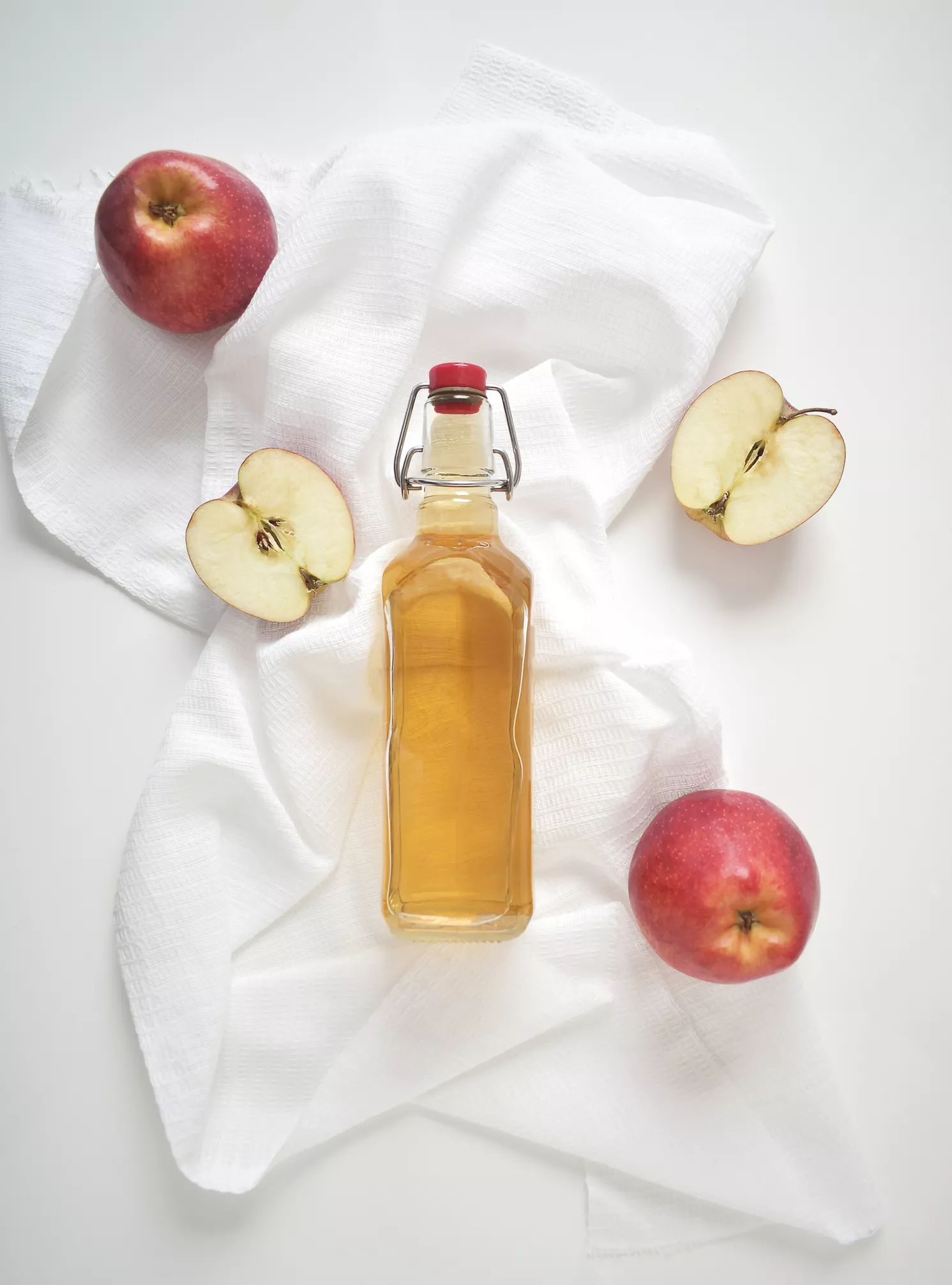 Apple cider vinegar or fermented fruit drink and organic apples on white