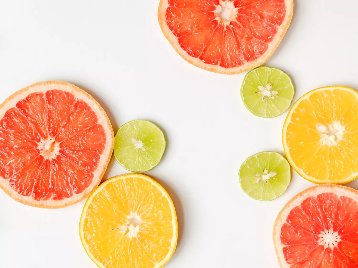 Close-up image of citrus fruit slices (grapefruit, lime, and orange) on a table