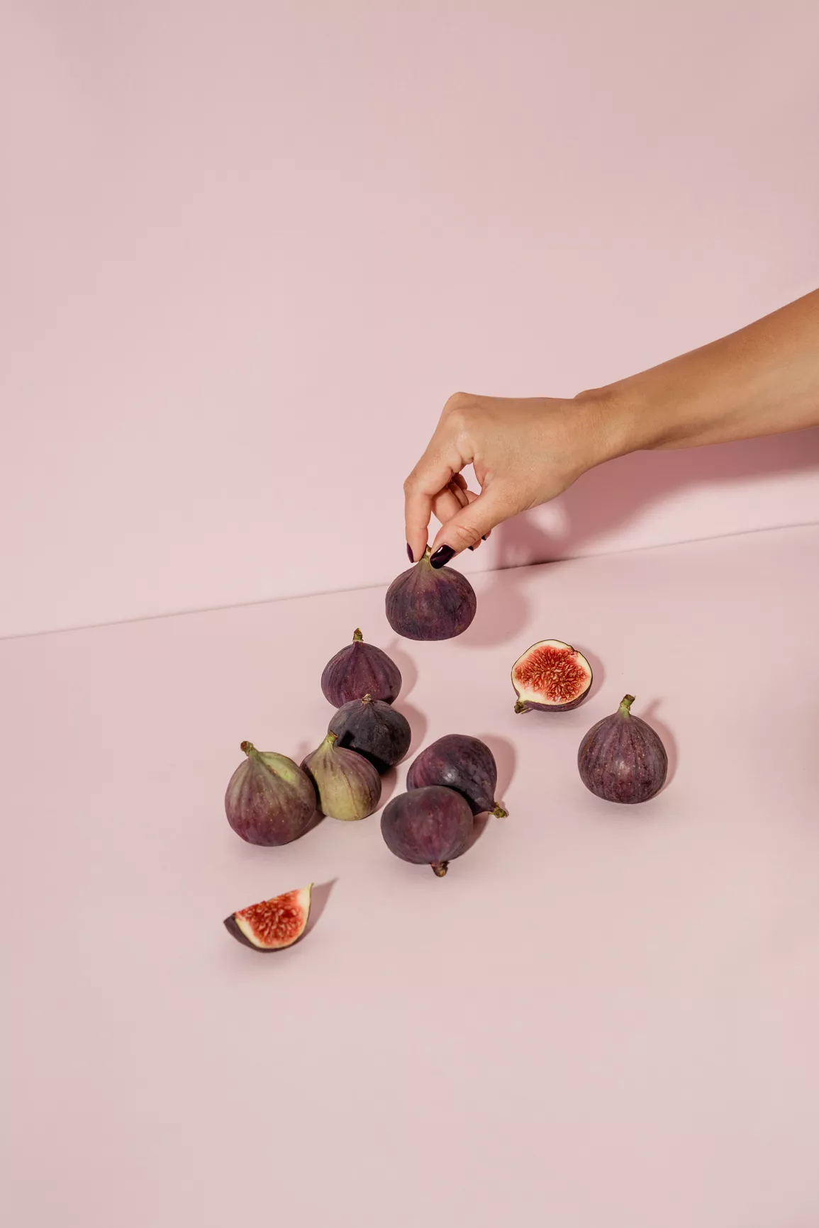 closeup of hand grabbing figs in studio