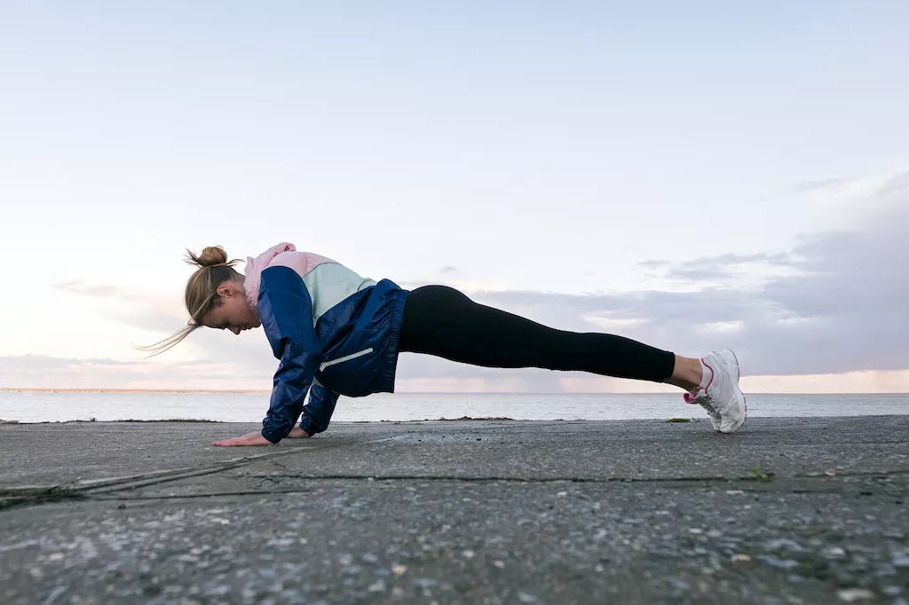 Woman performing a plank outdoors
