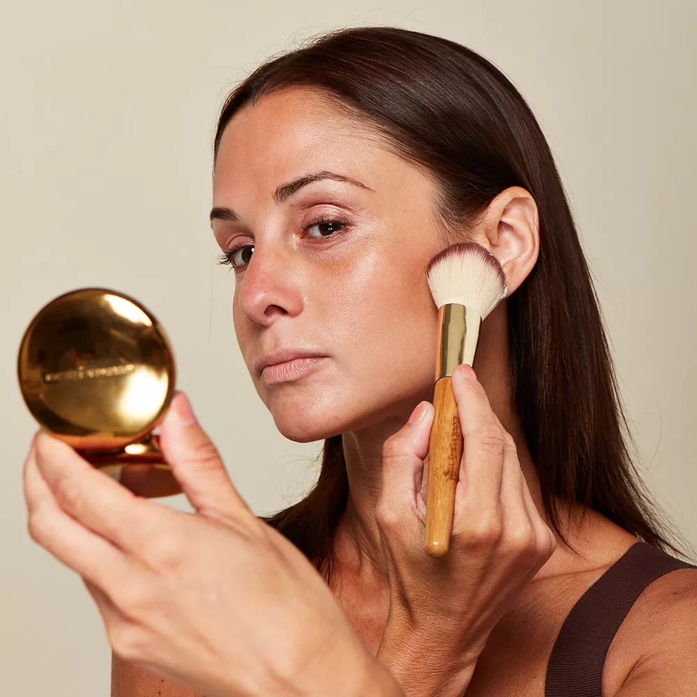 Woman with mature skin applying bronzer