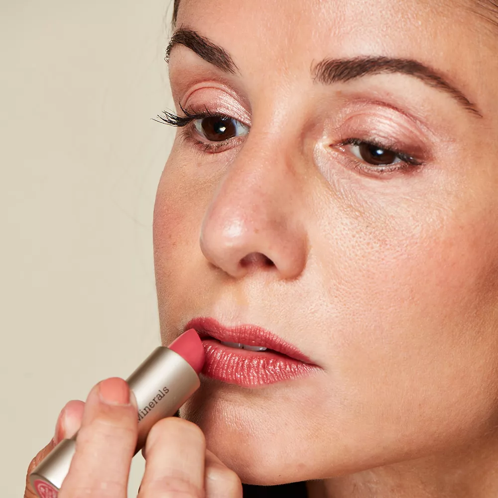 Woman with mature skin applying lipstick