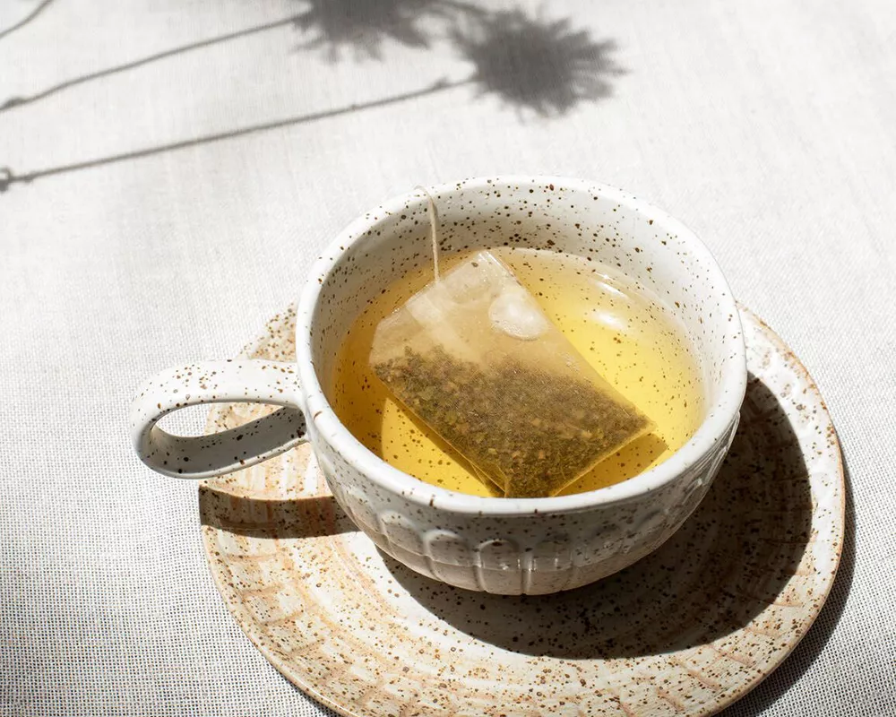 warm mug with tea and teabag in sunglight