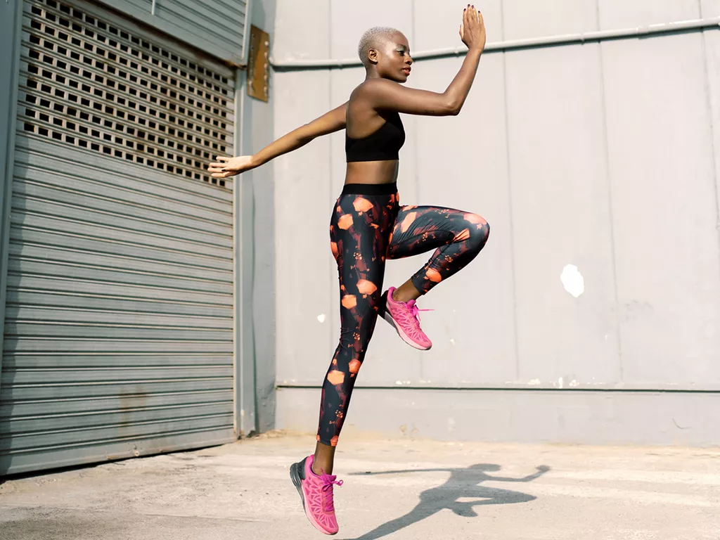 Woman in fitness clothes jumping mid-air