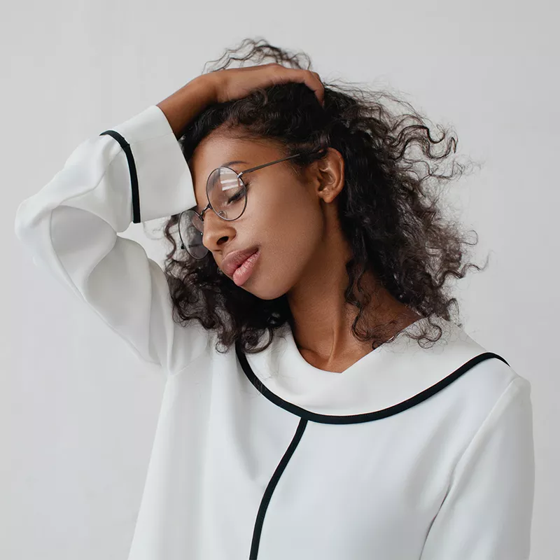 woman touching her hair and wearing a white blouse