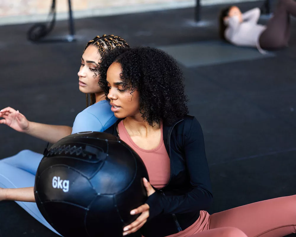 Women passing a fitness ball during a workout.