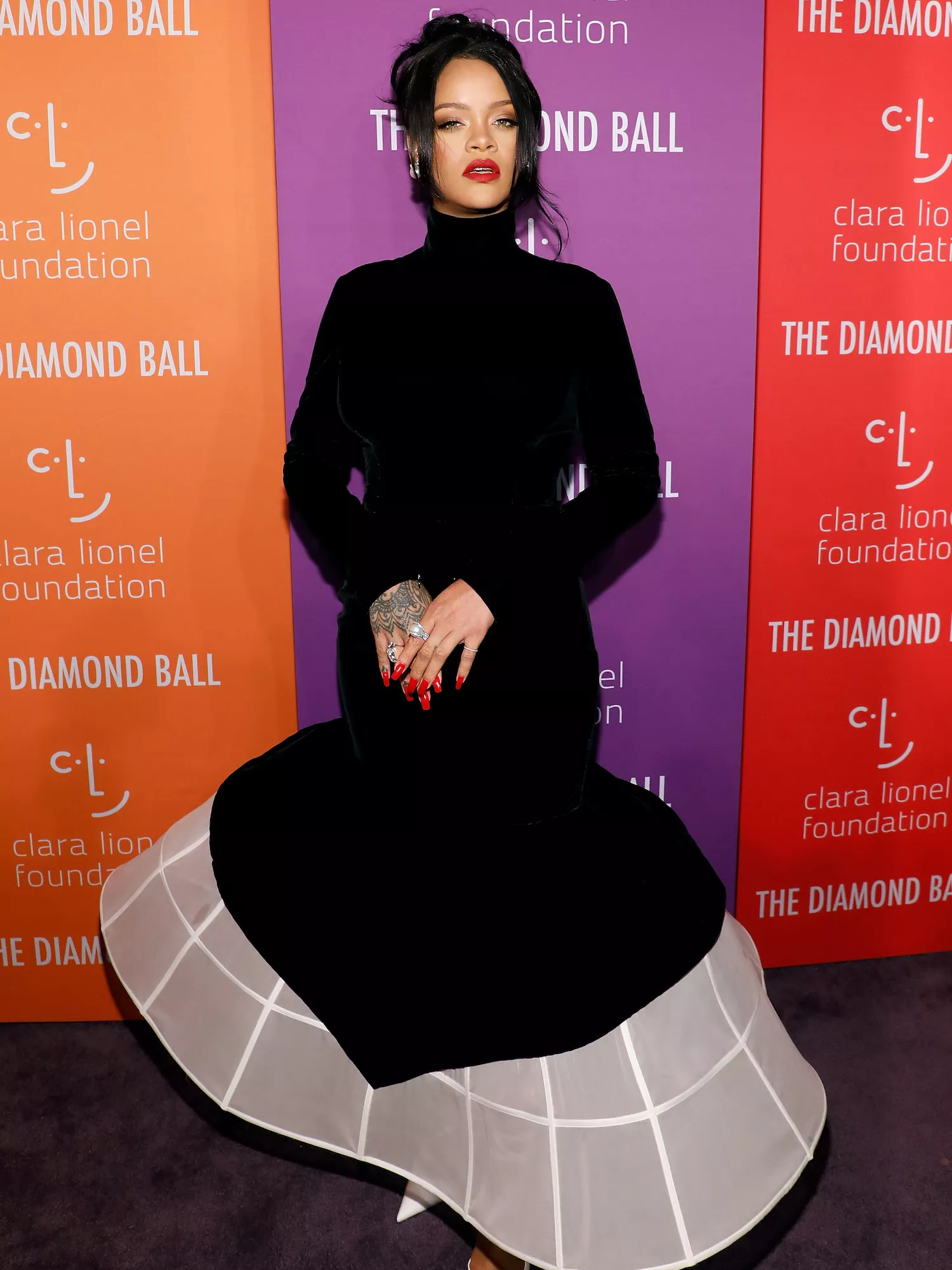 Rihanna wears a black Givenchy couture dress with drop waist and white hoop skirt to the 2019 Diamond Ball