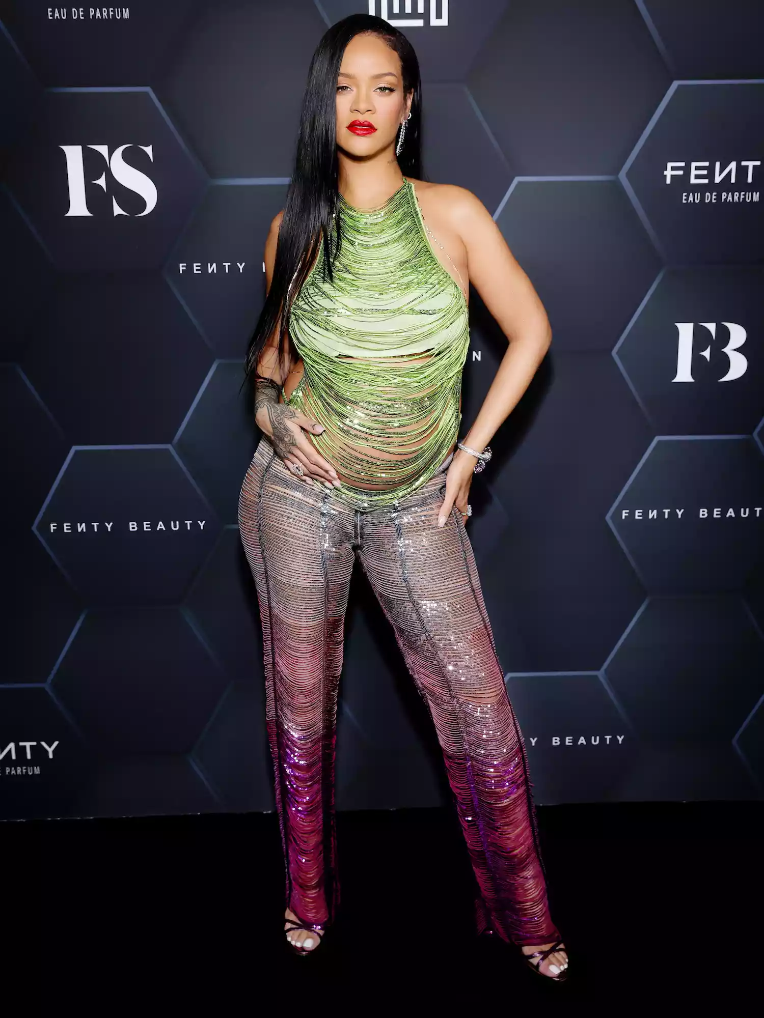 Rihanna wears a sparkly green shredded top and purple ombre pants to a Fenty Beauty event