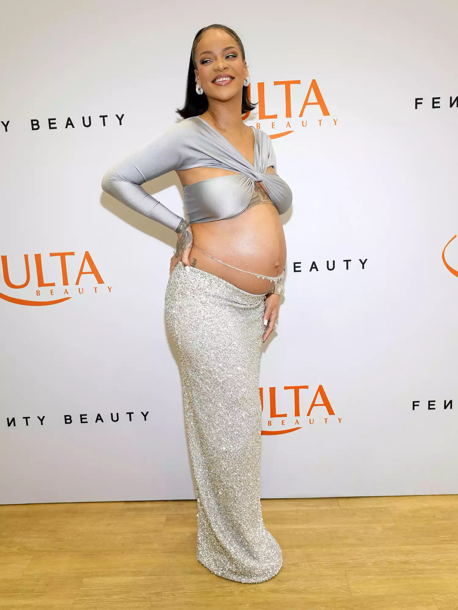 Rihanna wears a silver Coperni crop top and glitter maxi skirt to the Fenty Beauty launch at Ulta in 2022