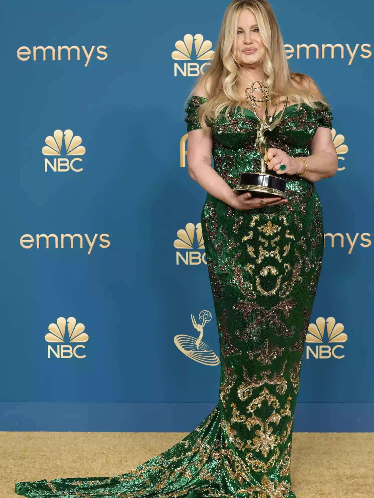 Jennifer Coolidge wears a green Dolce & Gabbana gown and holds her 2022 Emmy Awards trophy
