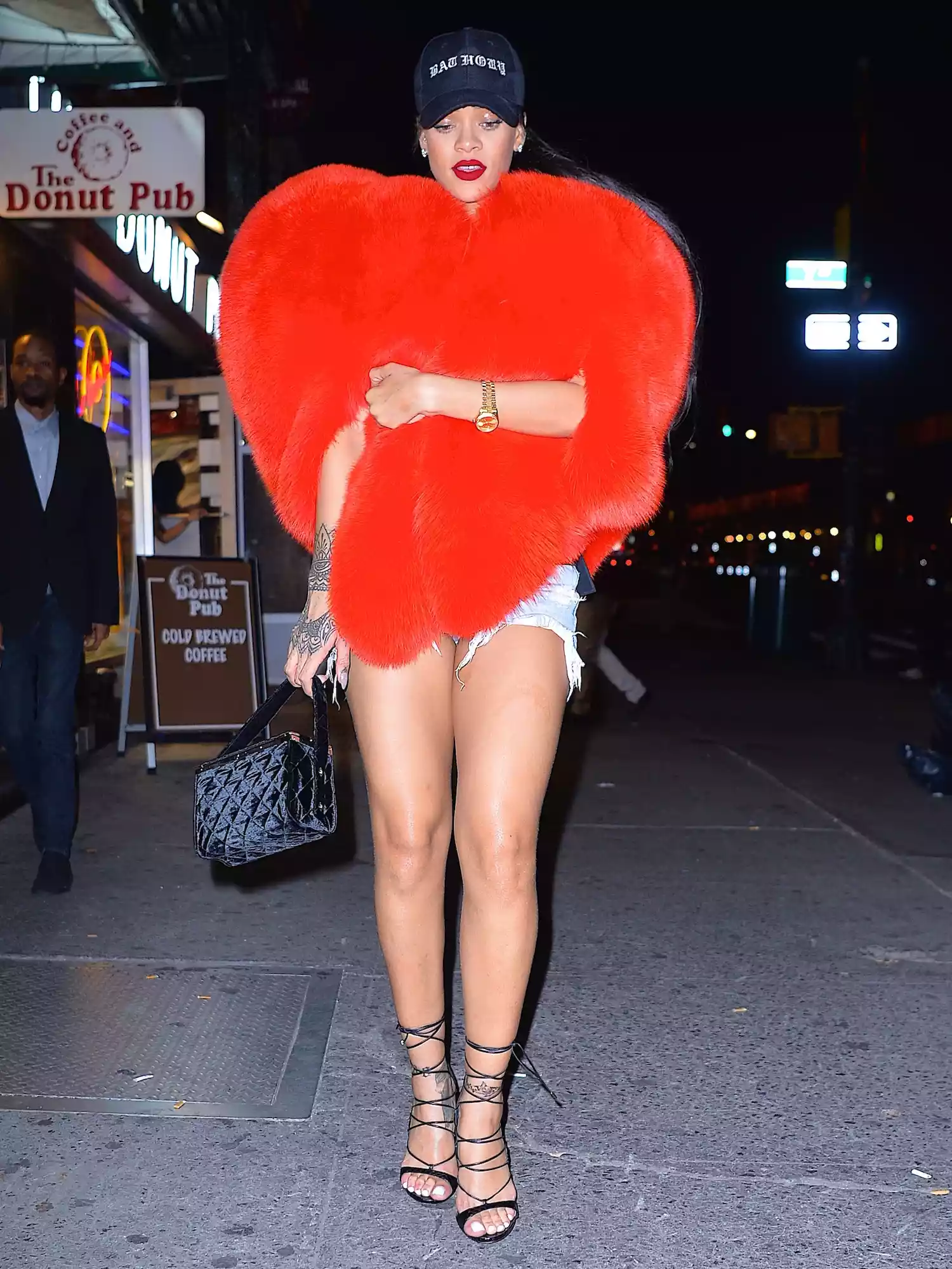 Rihanna wears a fur heart top, denim shorts, and strappy heels while out in New York City