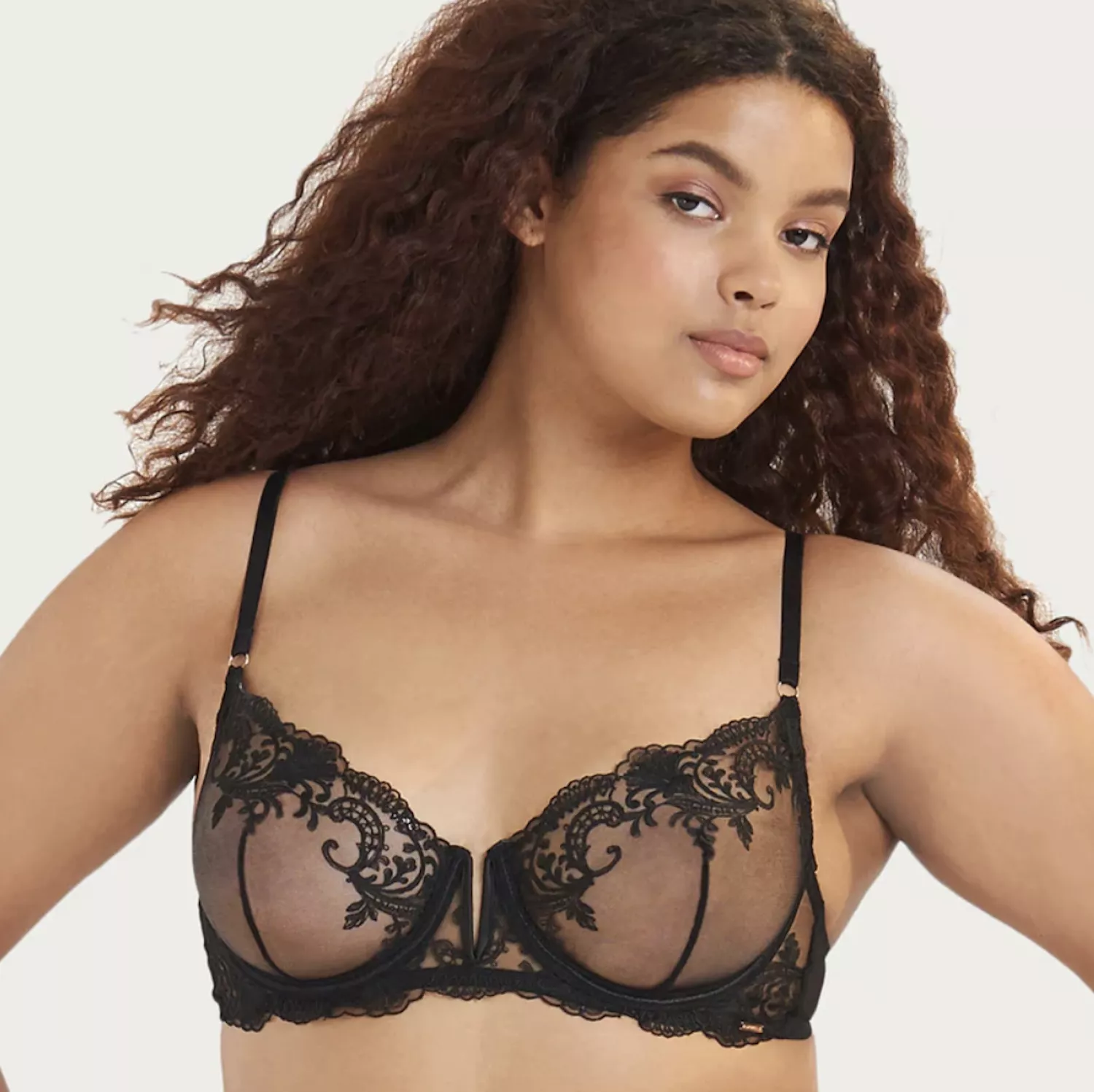 Model with curly hair wearing black sheer lace bra