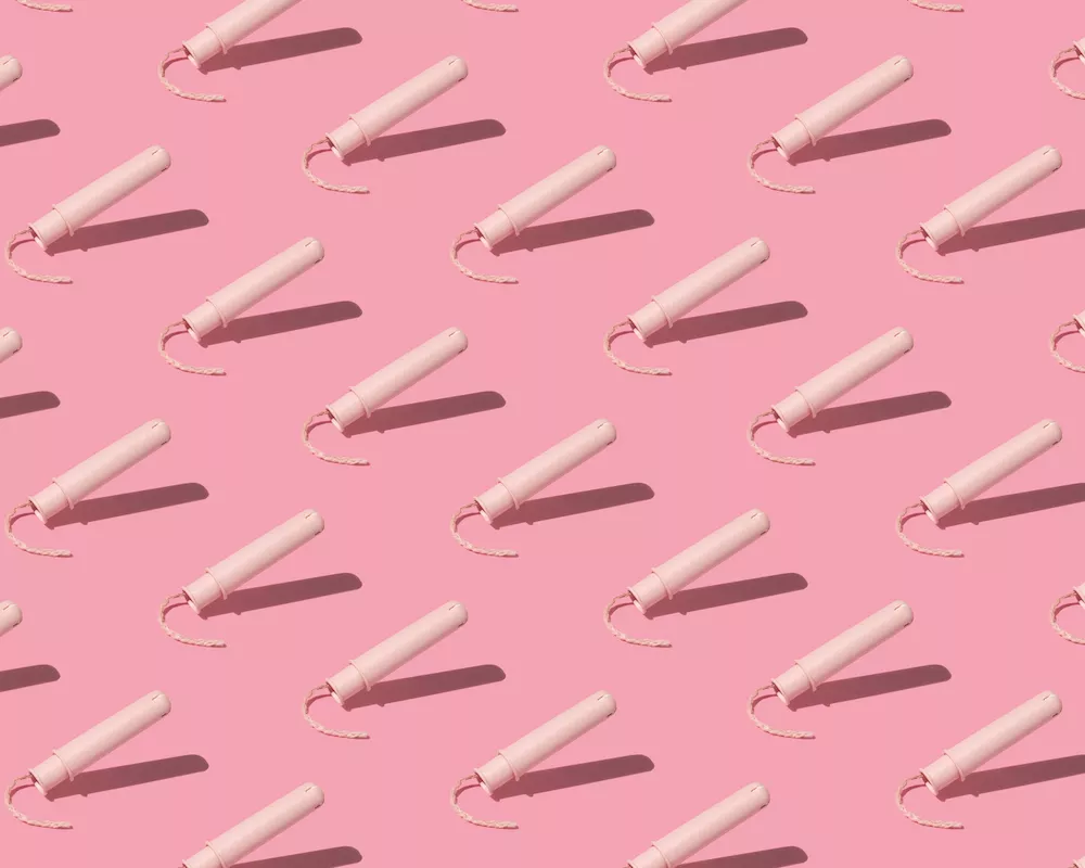 Pattern of tampons with pale pink applicators on pink background