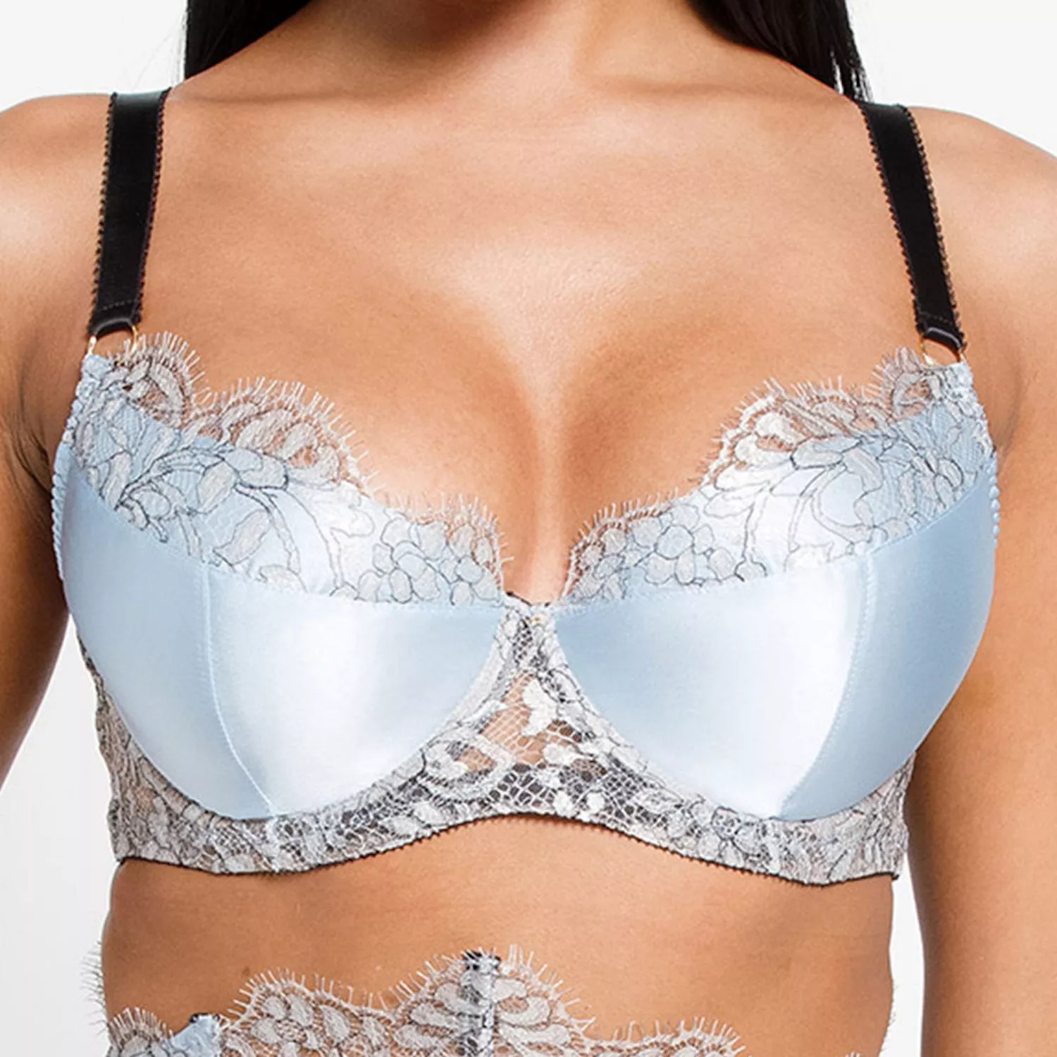 Close-up of model wearing baby blue satin bra with lace trim