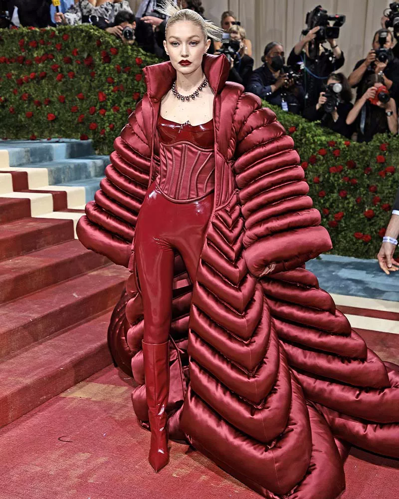 Gigi Hadid wearing a Versace red latex jumpsuit and puffer cape at the 2022 Met Gala.