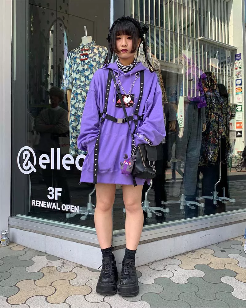 Woman wearing black platform sneakers and a purple hoodie