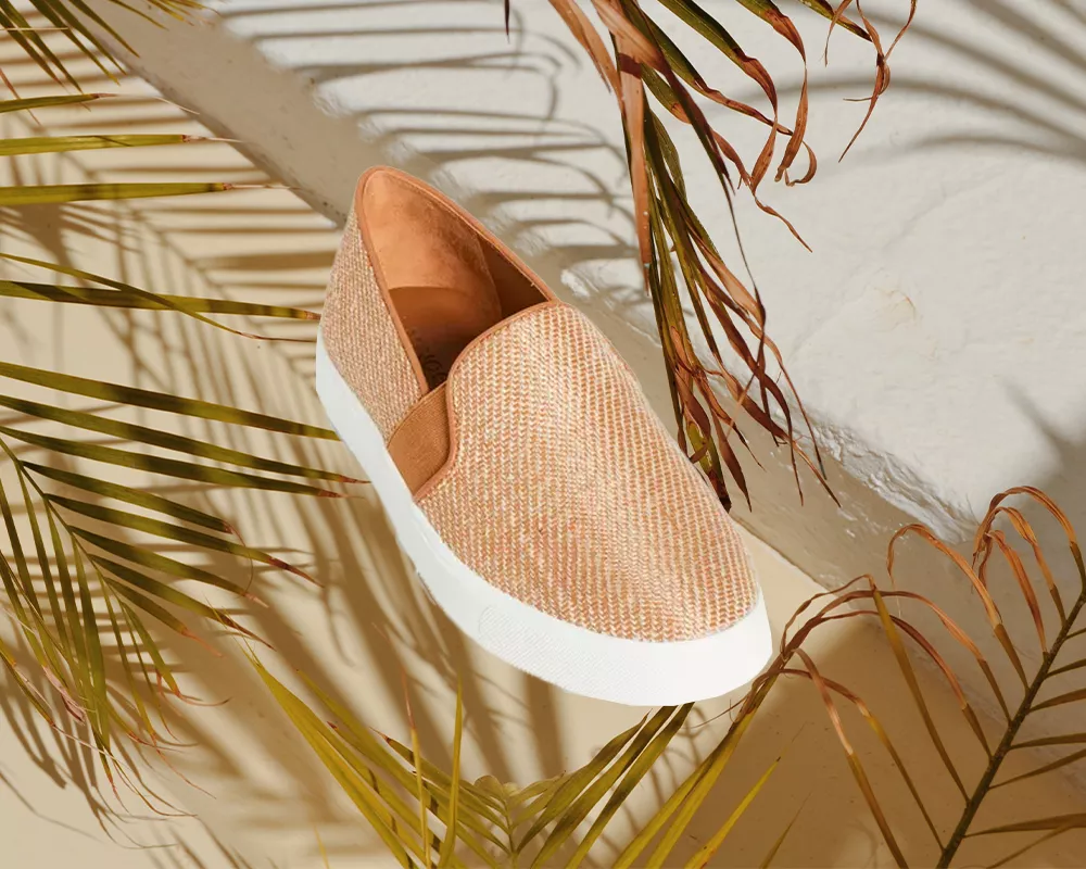 Woven slip on shoe against a palm tree background