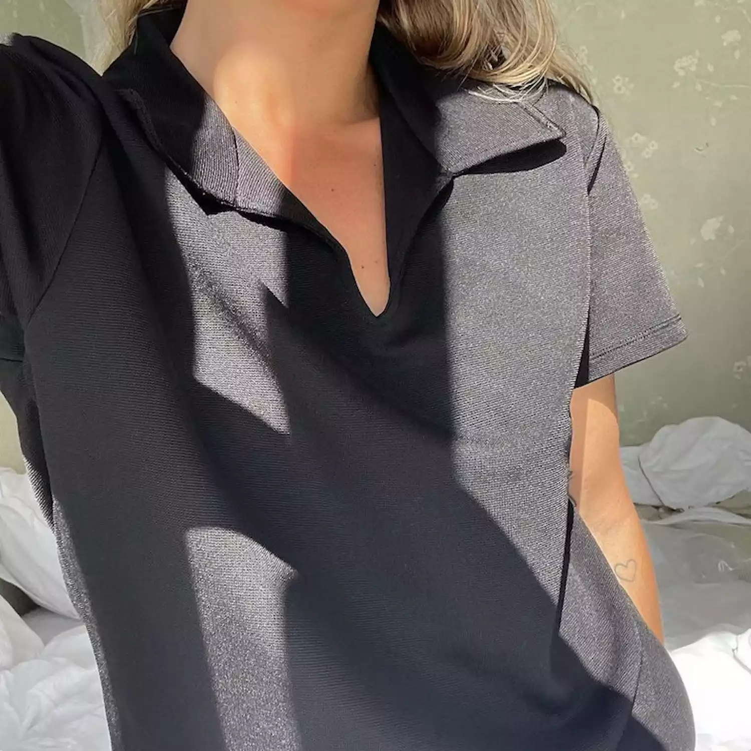 Matilda Djerf wears a black collared short-sleeved shirt with V neck